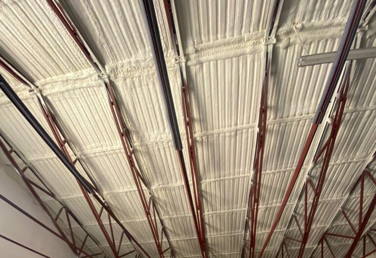 Izolacja poddasza wykonana pianą PUR, skutecznie ocieplająca dom. Widać dobrze nałożoną warstwę izolacyjną, która poprawia efektywność energetyczną budynku. Idealne rozwiązanie dla osób szukających odpowiednich metod ocieplania fundamentów i poddasza.